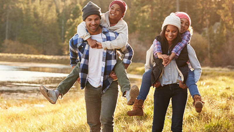 A healthy family walking in the fall leaves with strong immune health and overall wellness.