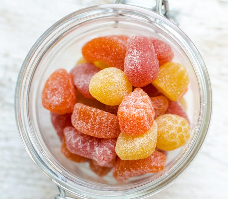 A jar of yellow, orange, and red gummy vitamins